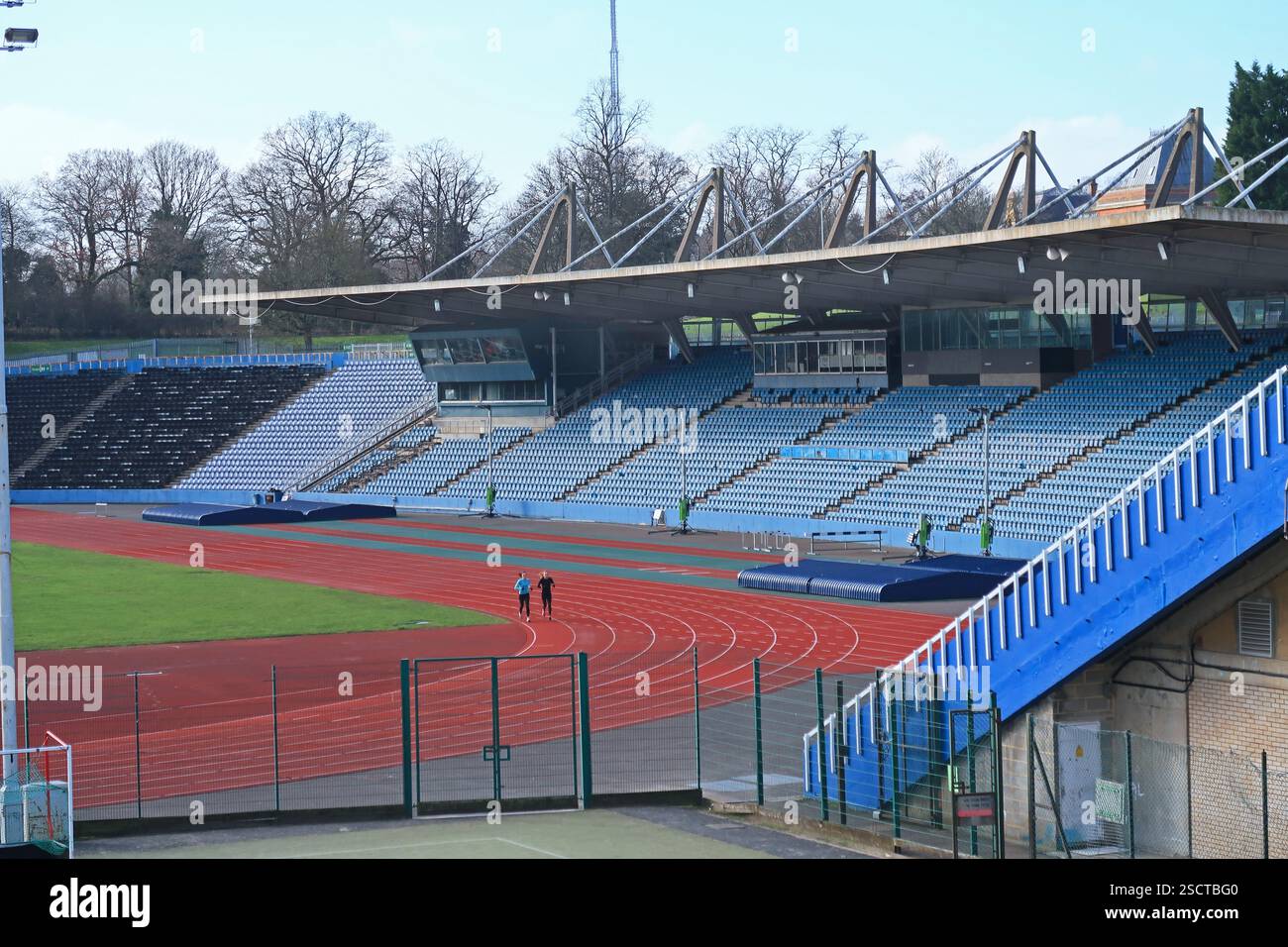Crystal Palace Athletics Stadium, Londra, Regno Unito. Due corridori si allenano nello stadio vuoto in una soleggiata giornata invernale Foto Stock
