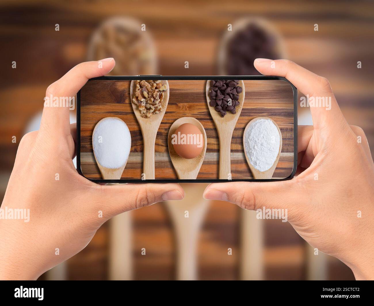 Cellulare che scatta una foto degli ingredienti dei biscotti con scaglie di cioccolato Foto Stock