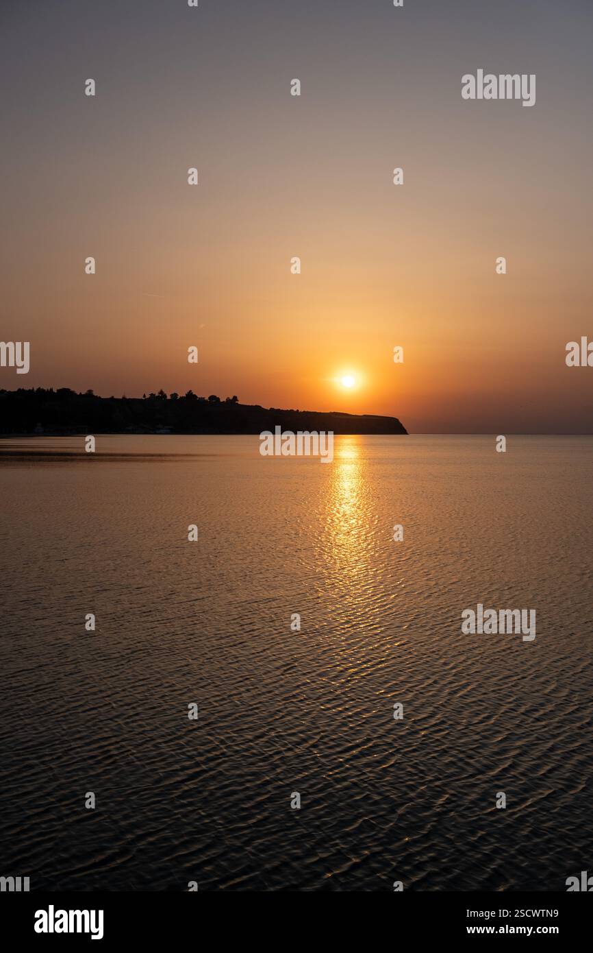 Tramonto con colori ricchi sul mare e sulla costa greca Foto Stock