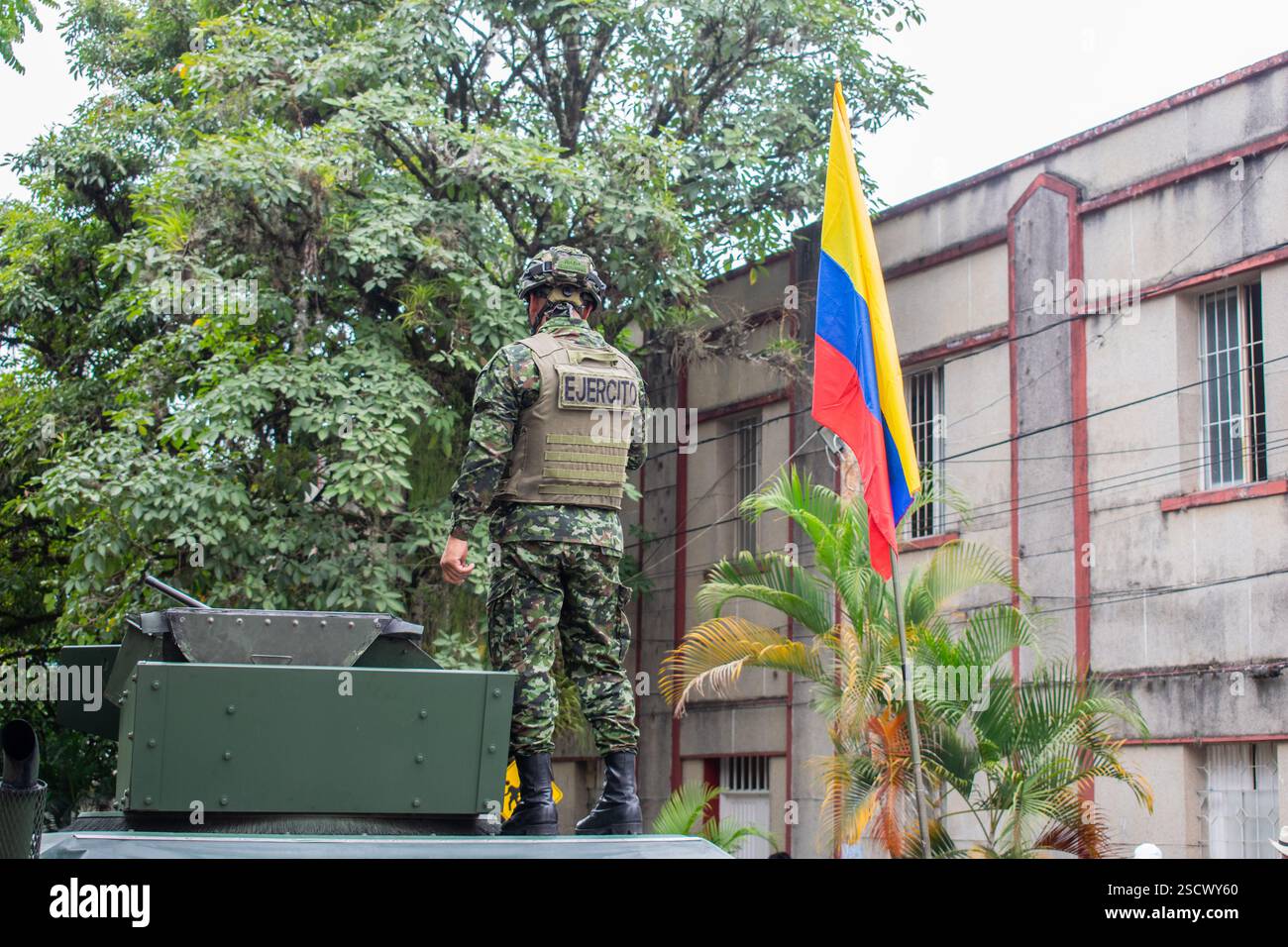 Soldato militare accanto alla bandiera della Colombia, soldato colombiano in piedi per bandiera nazionale, personale delle forze armate con bandiera colombiana. Foto di alta qualità Foto Stock