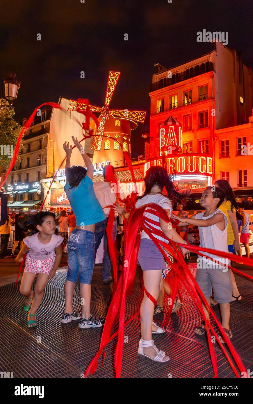 Parigi, Francia, bambini di gruppo che giocano con Ribbons, di notte, scene di strada nel quartiere di Pigalle, al teatro notturno del moulin rouge Foto Stock