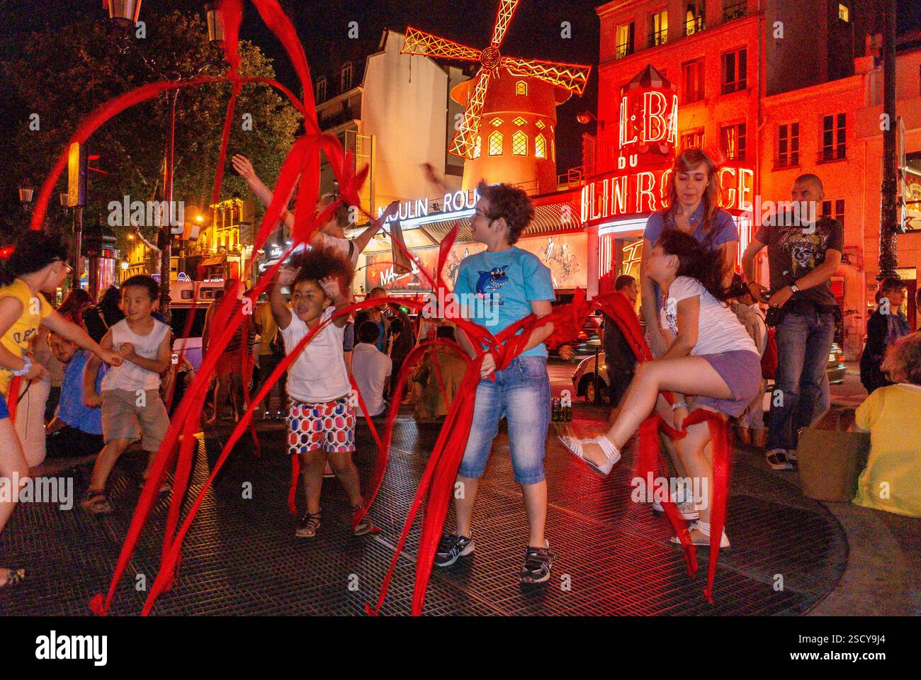 Parigi, Francia, bambini di gruppo che giocano con Ribbons, di notte, scene di strada nel quartiere di Pigalle, al teatro notturno del moulin rouge Foto Stock