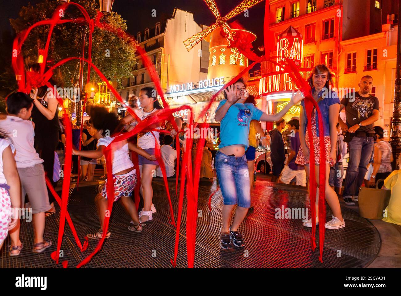 Parigi, Francia, bambini di gruppo che giocano con Ribbons, di notte, scene di strada nel quartiere di Pigalle, al teatro notturno del moulin rouge Foto Stock