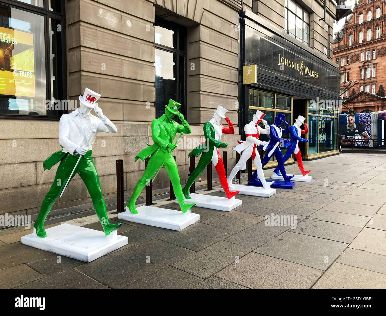 Johnnie Walker Whisky statue di striding man in colori Six Nations rugby fuori dalla Johnnie Walker Experience, Hope Street, Edimburgo, Scozia, 2025 Foto Stock