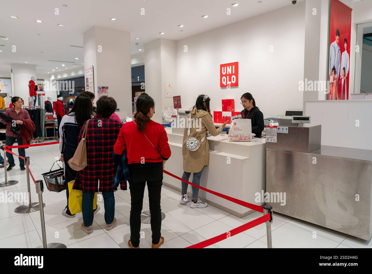 Shenzhen, Cina - 11 gennaio 2019: Clienti in coda al banco cassa all'interno di un negozio Uniqlo nel centro commerciale Vanke a Longgang, Shenzh Foto Stock