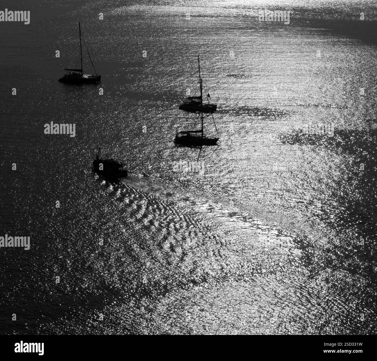 Yacht in mare al tramonto e riflessi sull'acqua Foto Stock