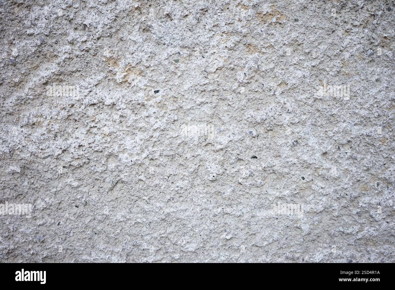 Una vista ravvicinata di una parete grigia testurizzata mostra la sua superficie ruvida. Sottili variazioni di colore e motivo creano interesse visivo per questi setti urbani Foto Stock