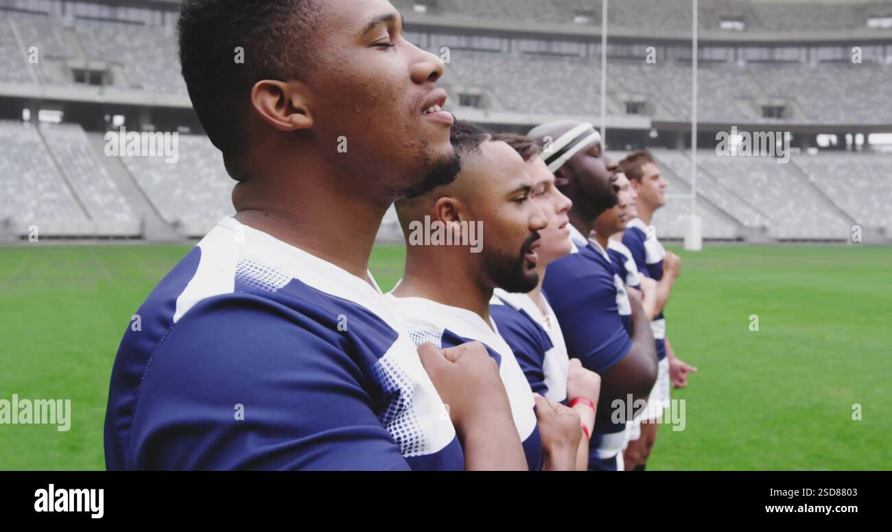 Giocatori di rugby in fila sul campo, che si tengono le mani al petto, mostrando unità Foto Stock