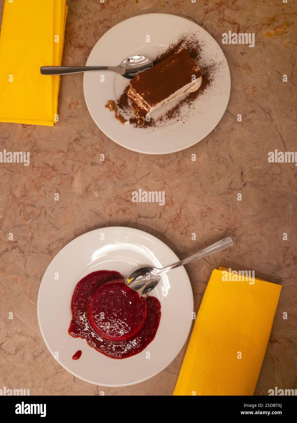 Due dessert italiani sul tavolo, panna cotta e tiramisù, vista dall'alto - Immagine stock catturata con smartphone