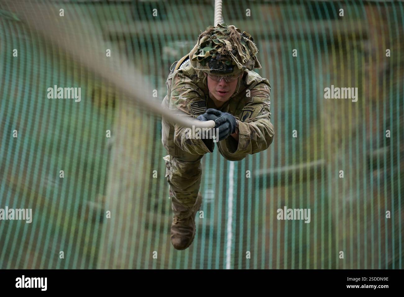 Un soldato degli Stati Uniti assegnato al 1st Squadron, 91st Cavalry Regiment, 173rd Airborne Brigade affronta un ostacolo di corda durante un giro nello sperone presso la Grafenwoehr Training area del 7th Army Training Command, Germania, 11 dicembre 2024. Lo scopo di questa corsa è quello di integrare nuovi paracadutisti nella cavalleria aviotrasportata e costruire uno spirito di corpo all'interno dello squadrone, incentrato sul patrimonio di cavalleria. La 173rd Airborne Brigade è la forza di risposta alle emergenze dell'Esercito degli Stati Uniti d'America in Europa, fornendo forze rapidamente schierabili nelle aree di responsabilità dell'Europa, dell'Africa e del comando centrale degli Stati Uniti. Estrazione in avanti Foto Stock