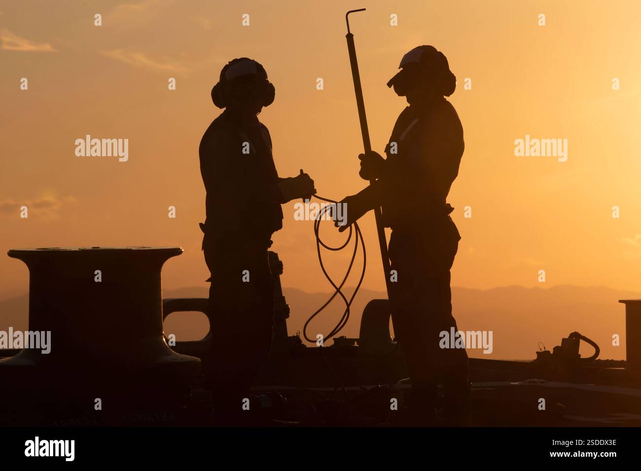 PHILIPPINE SEA (14 gennaio 2024) i marinai assegnati al cacciatorpediniere missilistico guidato classe Arleigh Burke USS Benfold (DDG 65) si preparano a rifornire un elicottero MH-60R assegnato all'Helicopter Maritime Strike Squadron (HSM) 51 mentre operano nel Mar delle Filippine, 14 gennaio. La Benfold è schierata in avanti e assegnata al Destroyer Squadron (DESRON) 15, il più grande DESRON della Marina e la principale forza di superficie della 7th Fleet. (Foto della Marina degli Stati Uniti di Monica Walker, specialista di comunicazione di massa di seconda classe) Foto Stock