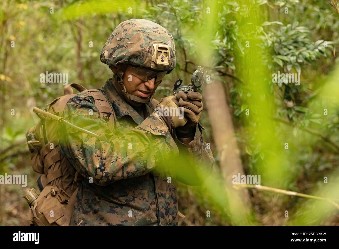 Juan Cruztrejo utilizza una bussola per sparare a un azimut durante un addestramento di navigazione terrestre presso la Central Training area Camp Hansen, Okinawa, Giappone, 10 dicembre 2024. I Marines hanno partecipato all'addestramento per la navigazione terrestre per aumentare le loro conoscenze sull'uso di una bussola e sulla tracciatura delle coordinate di griglia al fine di mantenere l'efficacia del combattimento e le abilità di base. Cruztrejo, nativo della Florida, è un fuciliere del 12th Marine Littoral Regiment, 3d Marine Division. (Foto del corpo dei Marines degli Stati Uniti di Evelyn Doherty) Foto Stock