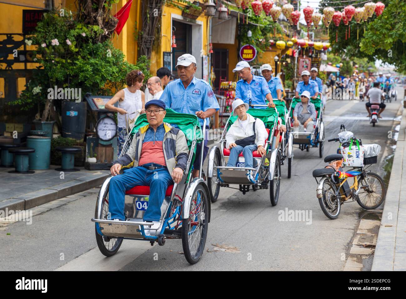 Gli autisti Cyclo trasportano passeggeri attraverso la strada di Hoi An, Vietnam, mercoledì 6 novembre 2024. Foto: David Rowland / One-Image.com Foto Stock