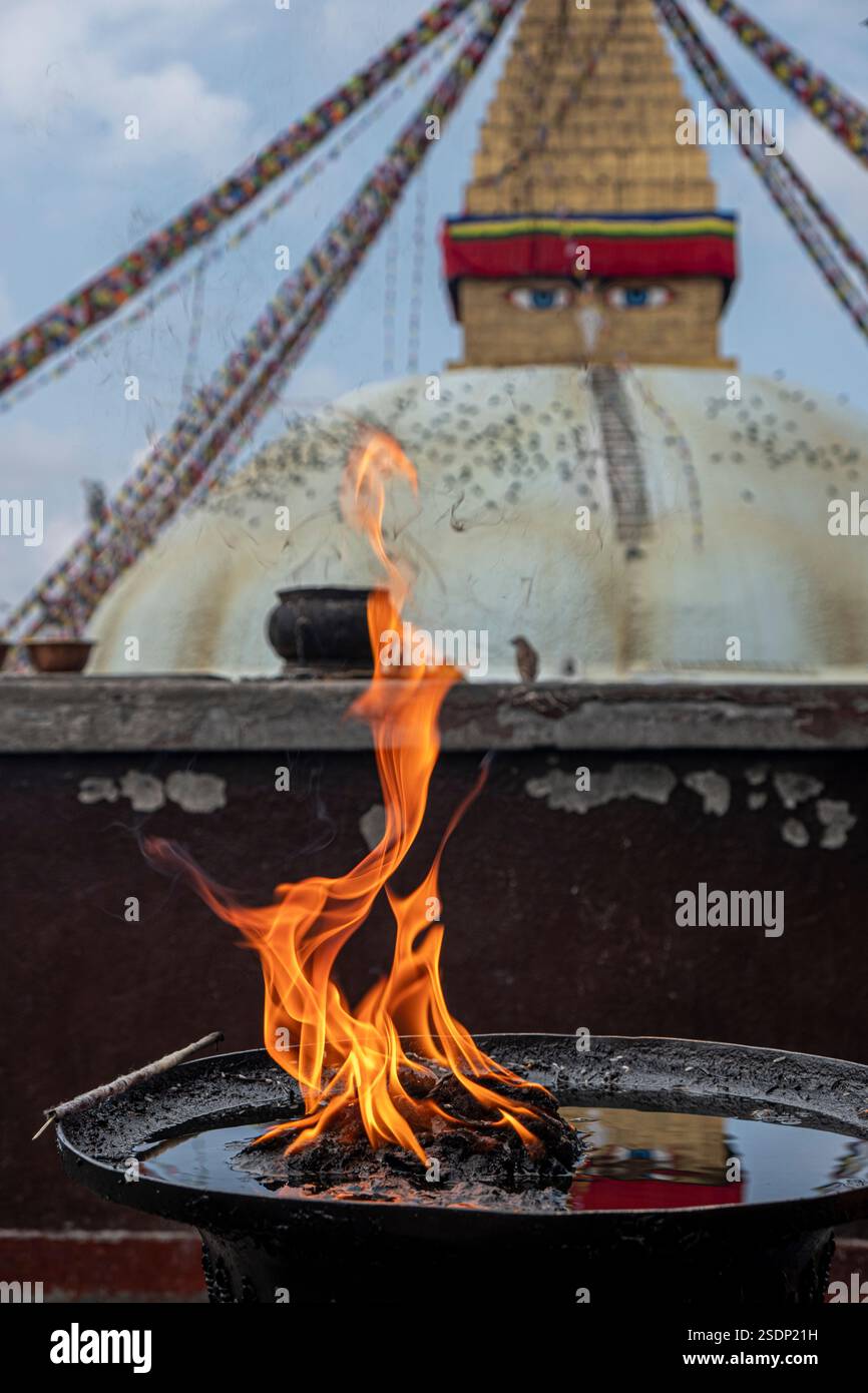 Fiamme della candela che danzano di fronte al Boudhanath Stupa a Kathmandu, Nepal Foto Stock