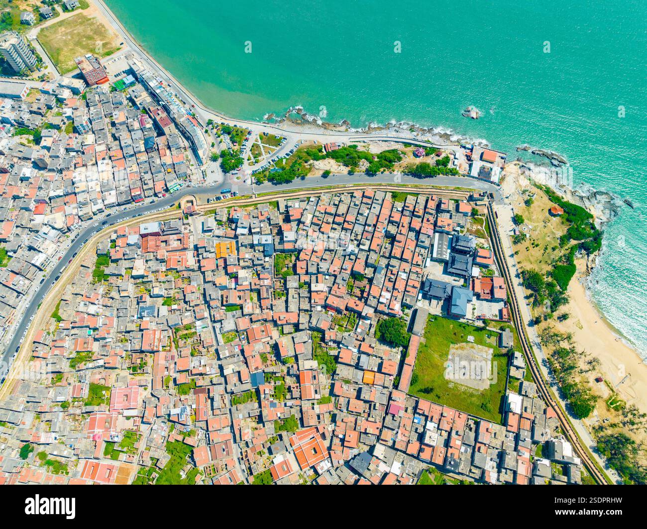 Veduta aerea di una città costiera con una spiaggia curva e l'Oceano Blu Foto Stock