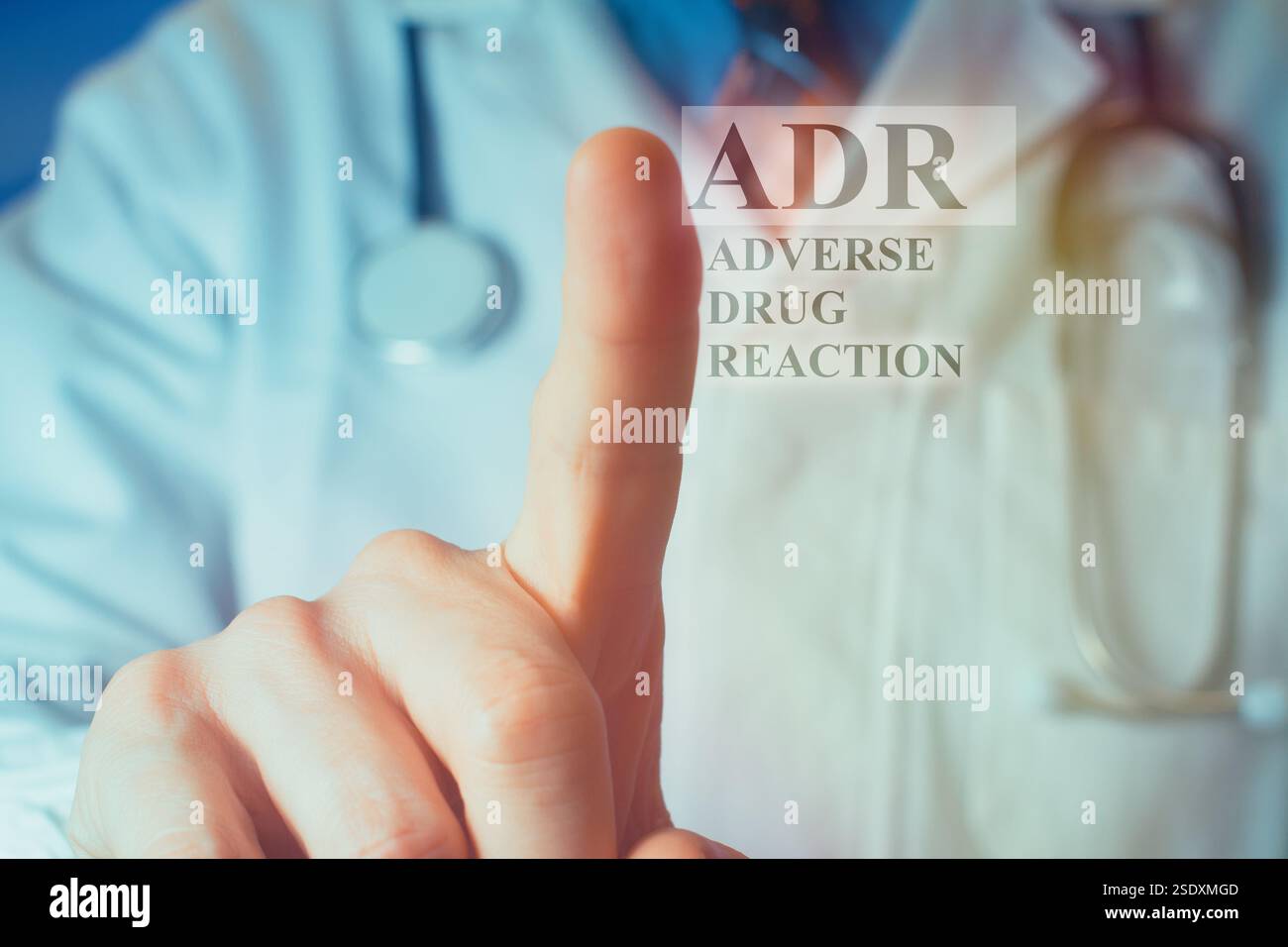 Vista ritagliata del giovane medico con un mantello bianco che punta il dito verso l'alto sulle lettere "ADR" Foto Stock