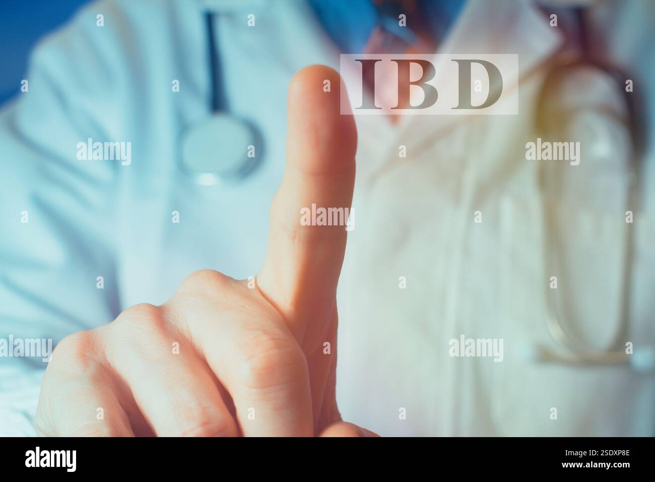 Vista ritagliata del giovane medico con un camice bianco che punta il dito verso l'alto sulle lettere "IBD". Concetto medico. Foto Stock