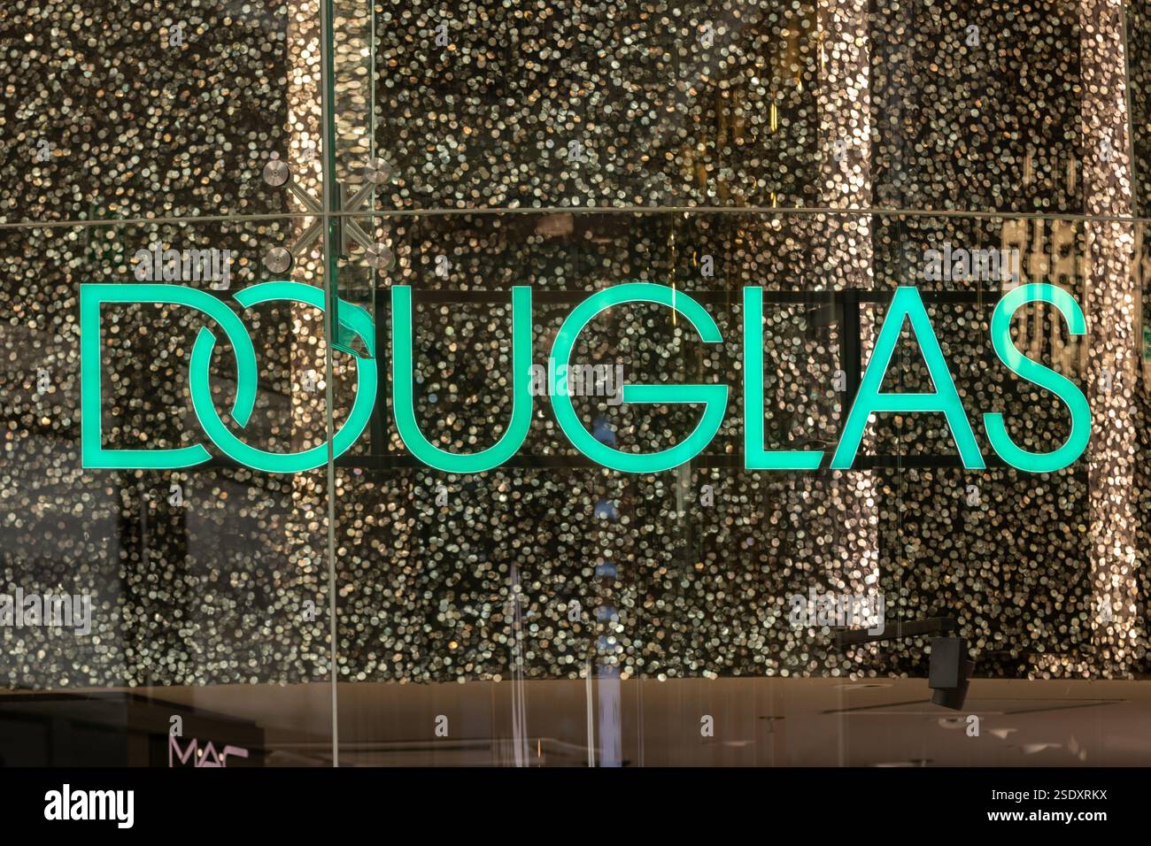 Negozio Douglas, logo illuminato con scintillanti sullo sfondo. Douglas è la più grande gamma di prodotti di bellezza online con consegna 24 ore su 24. Foto Stock