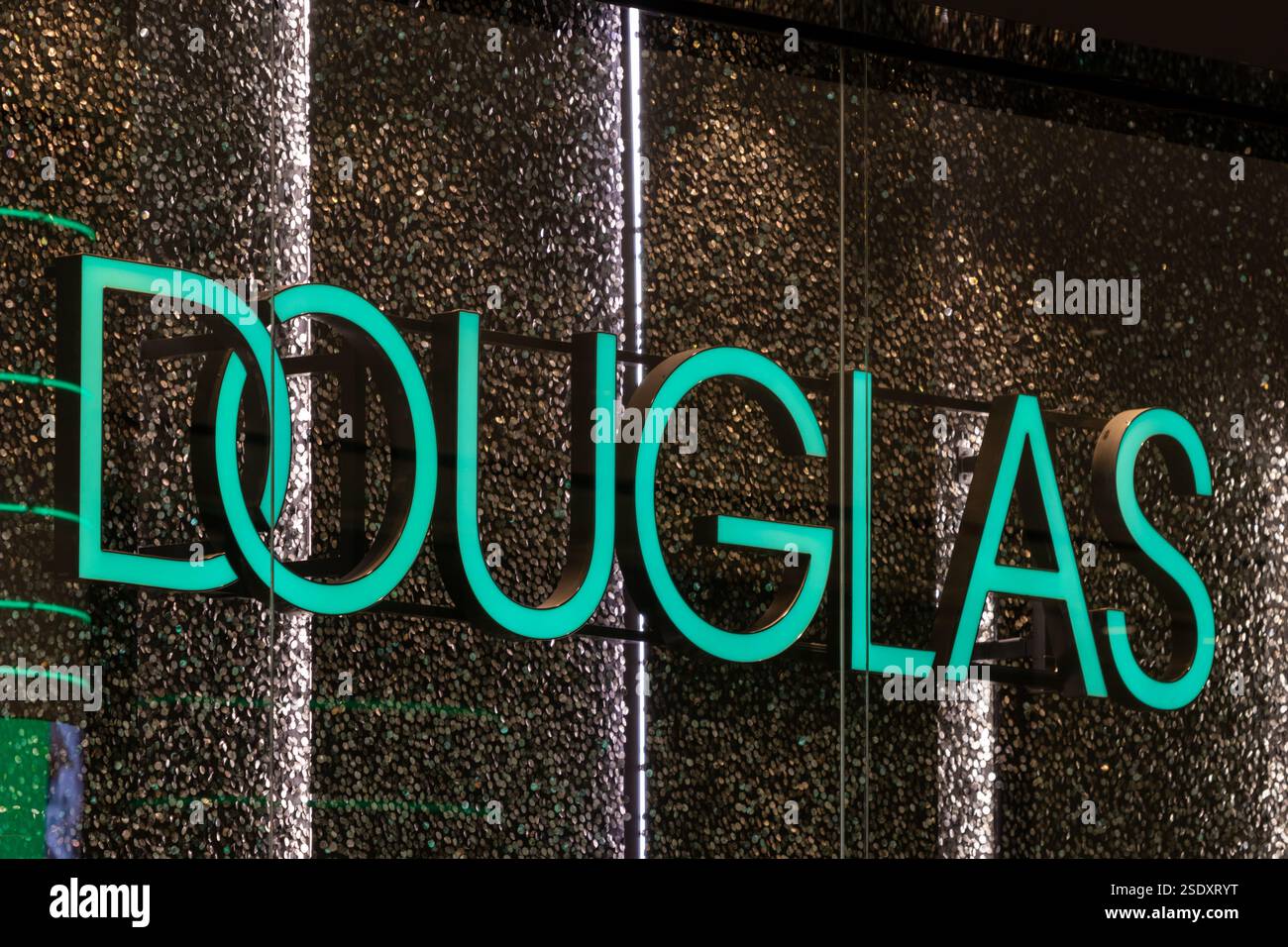 Negozio Douglas, logo illuminato con scintillanti sullo sfondo. Douglas è la più grande gamma di prodotti di bellezza online con consegna 24 ore su 24. Foto Stock