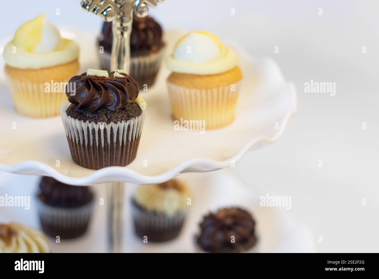 Cupcake al cioccolato e al limone su un tradizionale banco per dolci per il tè di Pasqua e del pomeriggio; concetto per il tè, i compleanni e la festa della mamma. Foto Stock