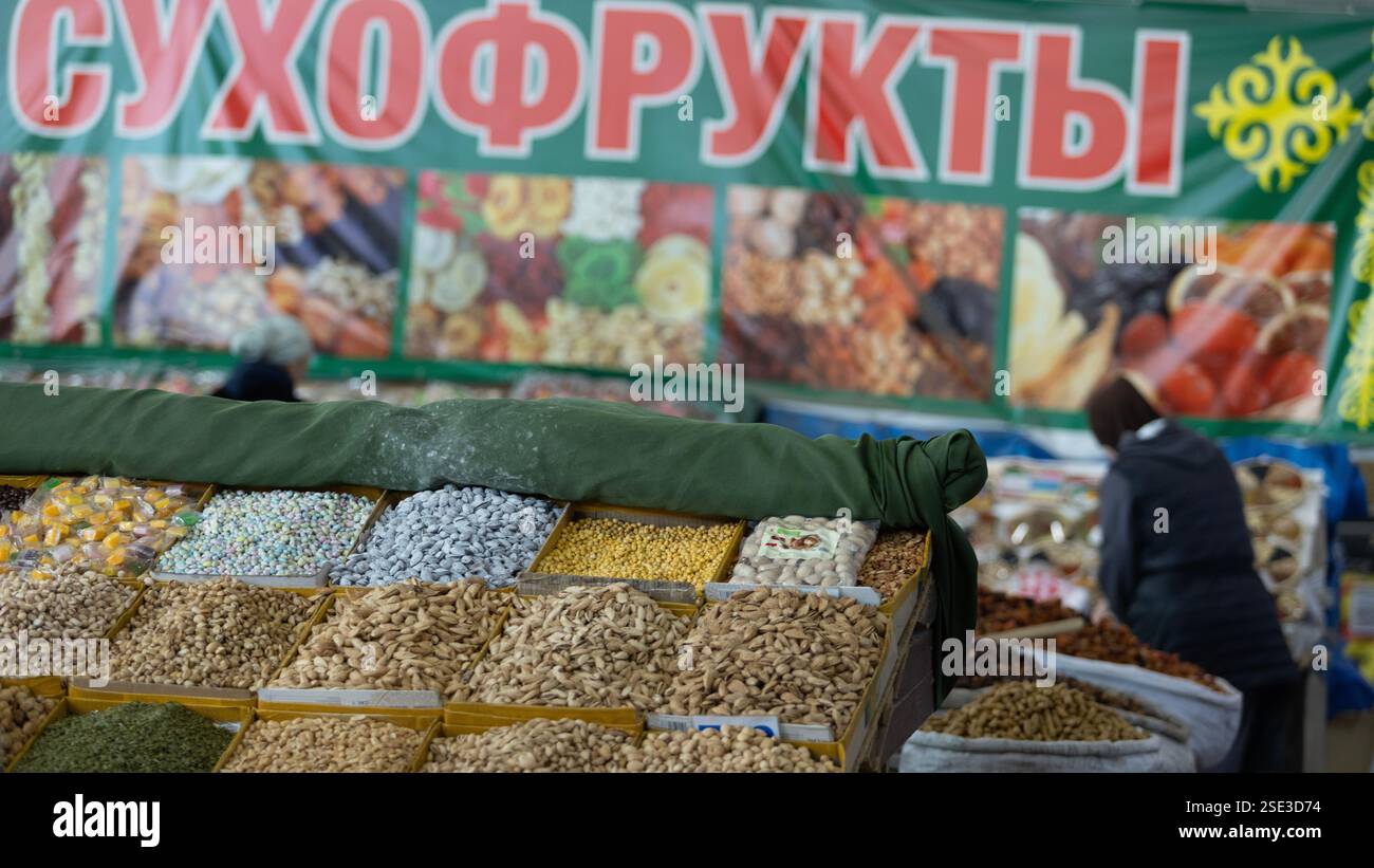 Bishkek, Kirghizistan 11 ottobre 2024: hawker vende le noci e la frutta secca in Osh Bazaar. OSH Bazaar è uno dei più grandi bazar del Kirghizistan. Foto Stock