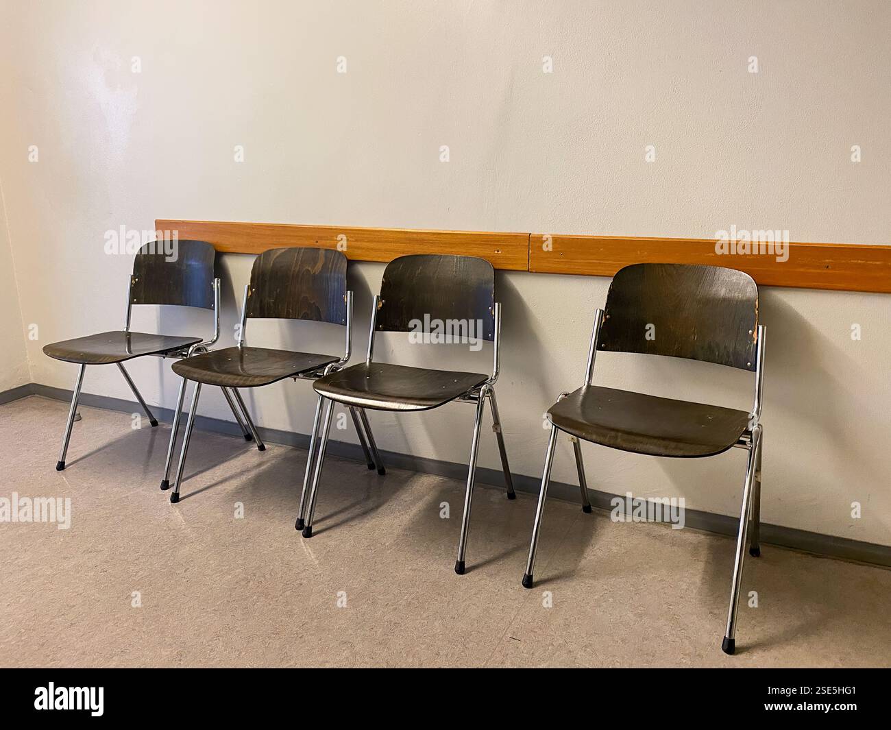 Quattro sedie in legno in un tranquillo corridoio dell'edificio governativo - scena dell'area d'attesa Foto Stock