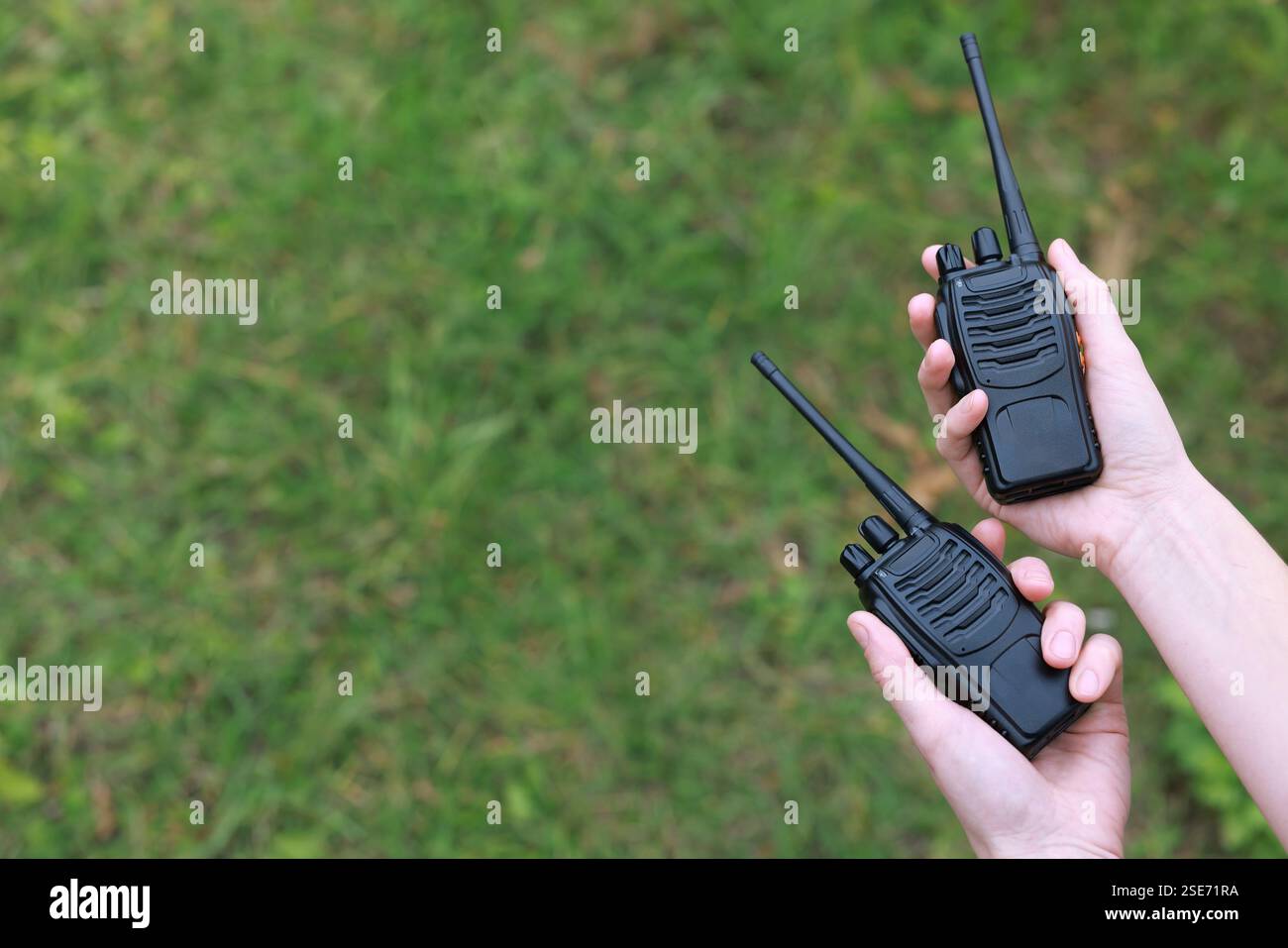 Donna con walkie talkie all'aperto, primo piano. Spazio per il testo Foto Stock