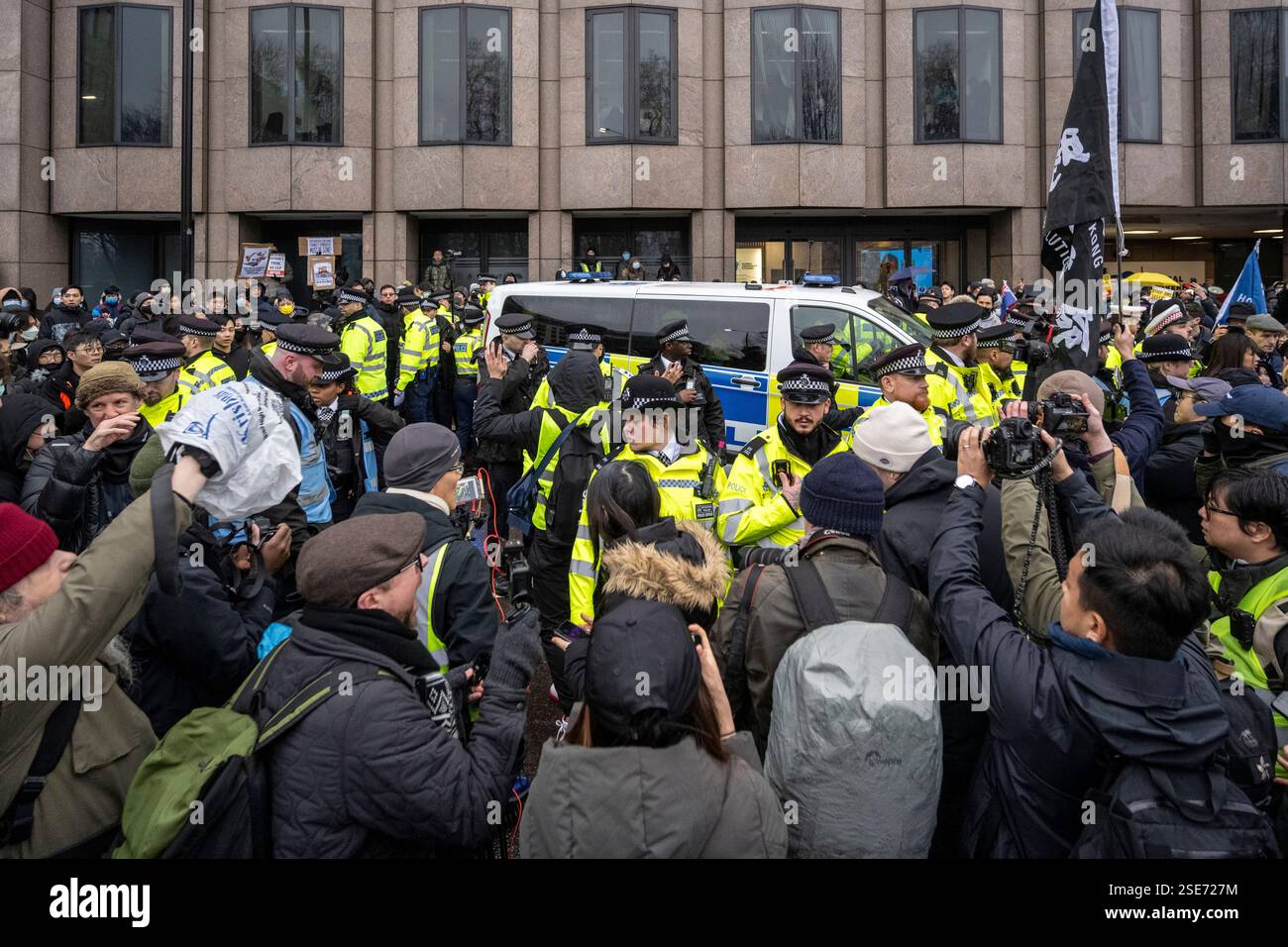 Londra, Regno Unito. 8 febbraio 2025. La polizia gestisce i manifestanti con cartelli fuori dalla Royal Mint Court, vicino alla Torre di Londra, contestando la proposta della nuova “super ambasciata” della Cina, che sarebbe la più grande ambasciata d’Europa. La prossima settimana inizierà un'audizione istruttoria llocale e la decisione finale spetta ad Angela Rayner, vice primo ministro e segretaria per gli alloggi. I residenti locali e i gruppi di campagna che rappresentano uiguri, tibetani, Hong Kongers e dissidenti cinesi si oppongono alla proposta. Crediti: Stephen Chung / Alamy Live News Foto Stock