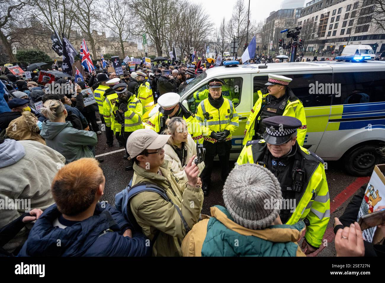 Londra, Regno Unito. 8 febbraio 2025. La polizia gestisce i manifestanti con cartelli fuori dalla Royal Mint Court, vicino alla Torre di Londra, contestando la proposta della nuova “super ambasciata” della Cina, che sarebbe la più grande ambasciata d’Europa. La prossima settimana inizierà un'audizione istruttoria llocale e la decisione finale spetta ad Angela Rayner, vice primo ministro e segretaria per gli alloggi. I residenti locali e i gruppi di campagna che rappresentano uiguri, tibetani, Hong Kongers e dissidenti cinesi si oppongono alla proposta. Crediti: Stephen Chung / Alamy Live News Foto Stock