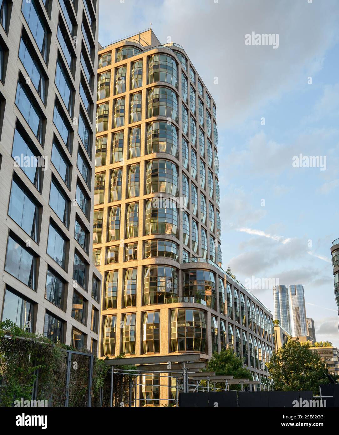 Gli edifici contemporanei presentano facciate in vetro riflettente e forme uniche, catturando la bellezza dell'innovazione architettonica mentre il sole tramonta nel cit Foto Stock