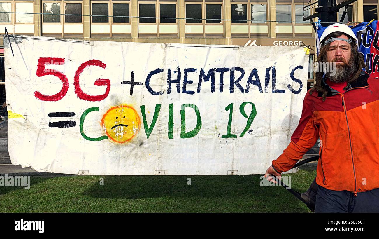 Glasgow, Scozia, Regno Unito. 8 febbraio 2025. Meteo nel Regno Unito: Soleggiata giornata primaverile e freddo in città come appaiono i primi segnali. Io il centro della città. Il tempo primaverile ha fatto emergere lo strano mentre il manifestante contro tutto ciò che ha fatto a george Square. Credit Gerard Ferry/Alamy Live News Foto Stock