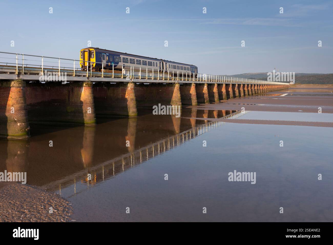 Treno sprinter di classe 156 della Northern Rail che attraversa il viadotto kent ad Arnside, sull'estuario del Kent, linea ferroviaria costiera della Cumbria Foto Stock