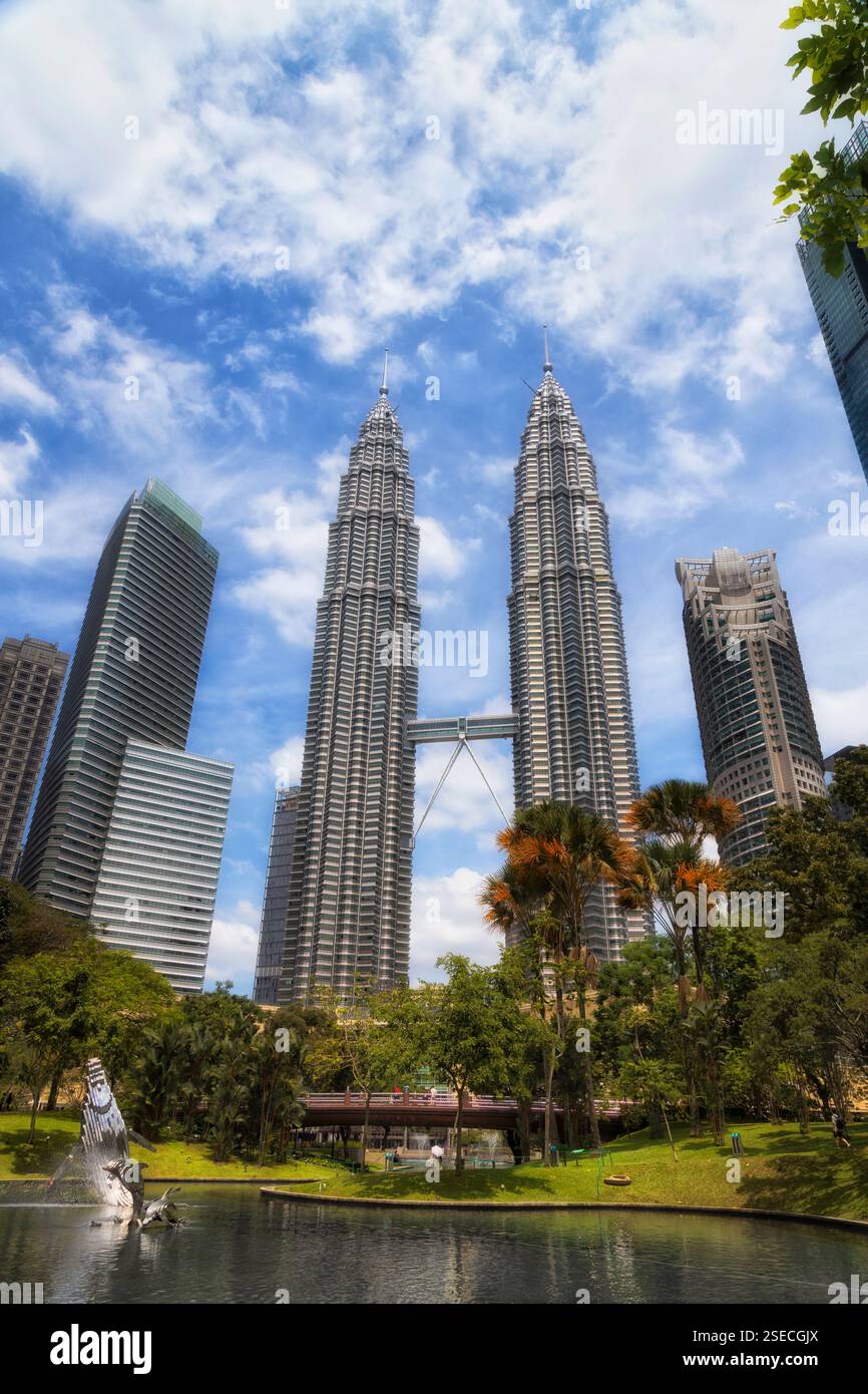 Parco cittadino e stagno a Kuala Lumpur, in Malesia, con alte torri di architettura urbana. Foto Stock