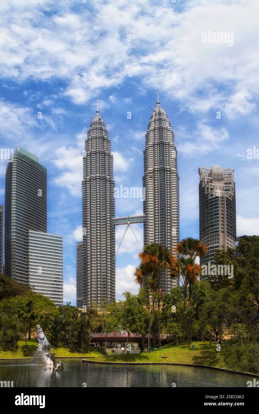 Parco cittadino e laghetto a Kuala Lumpur, in Malesia, con alte e dritte torri dall'architettura urbana. Foto Stock