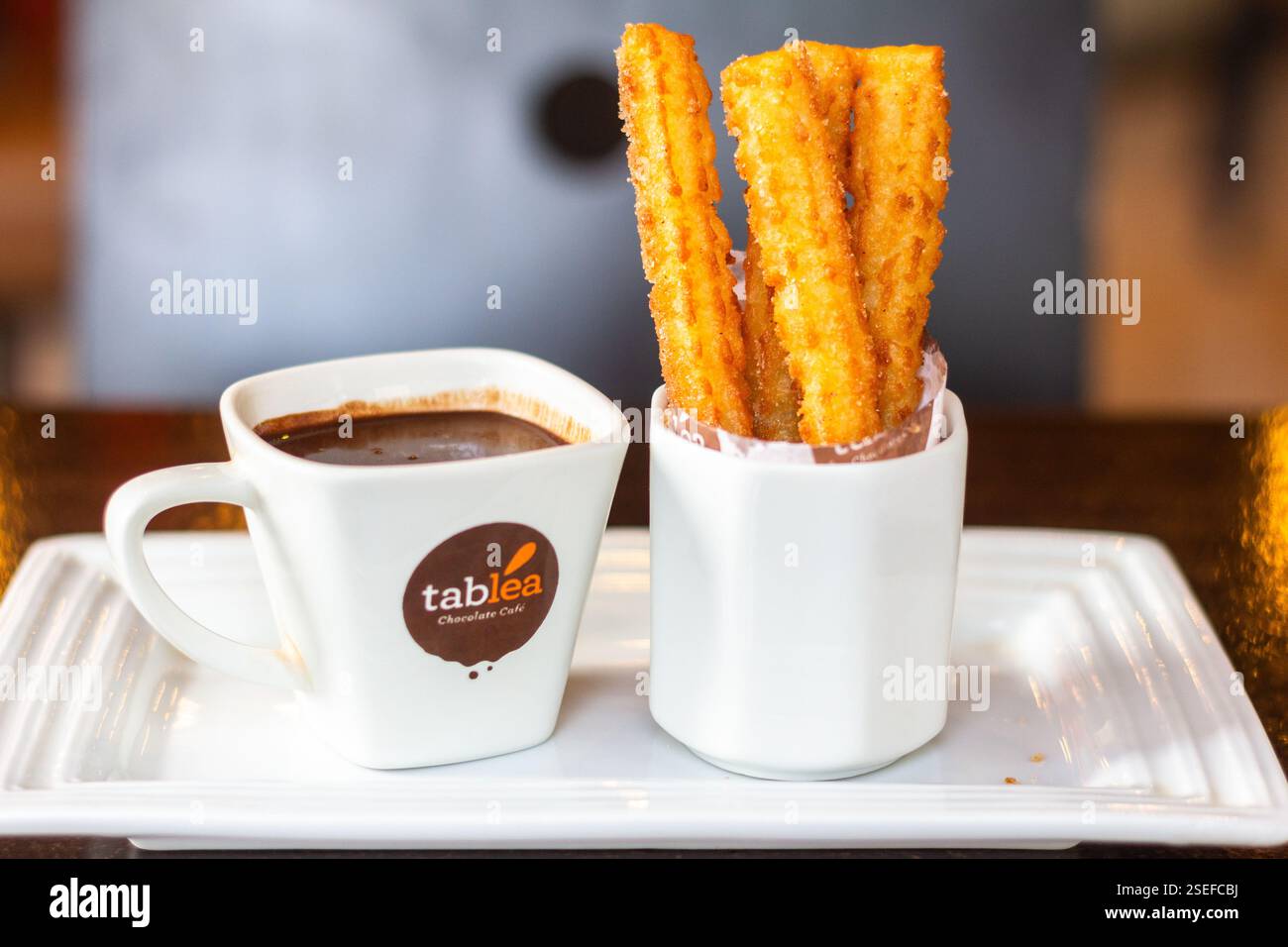 Churros con cioccolata calda spessa fatta con tablea Cebu serviti su un tavolo di legno al Tablea Cafe Foto Stock