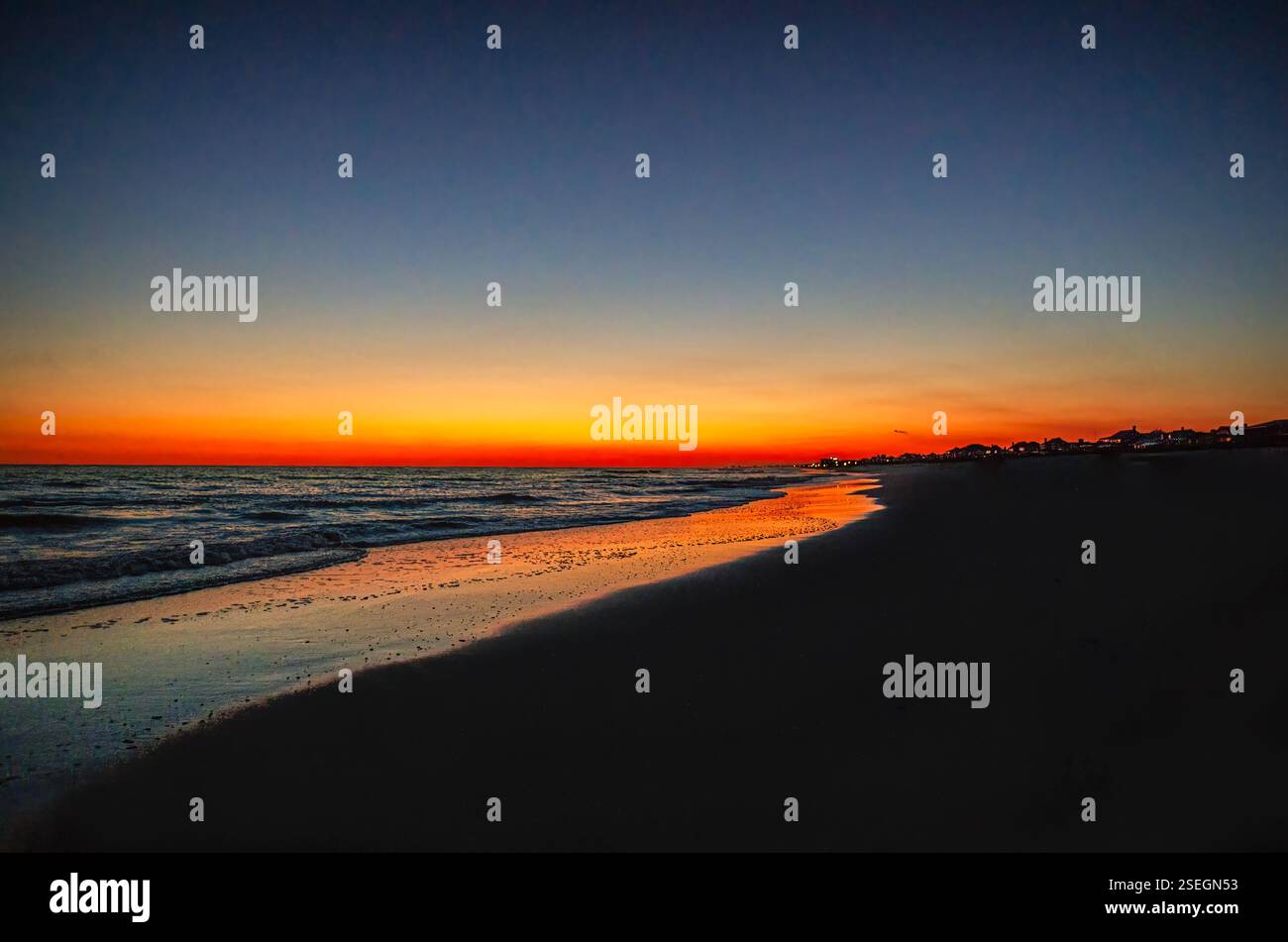 Tramonto vibrante su Atlantic Beach, North Carolina, con riflessi dorati sulla costa e cielo scuro. Foto Stock