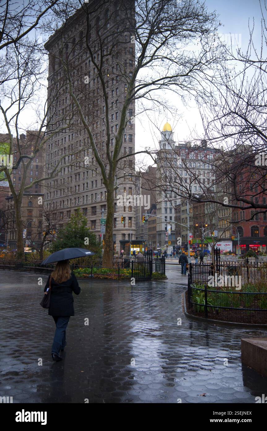 Cammina sotto la pioggia nel parco di Madison Square fino all'edificio Flatiron, Manhattan, NYC, New York City, USA, nord America Foto Stock