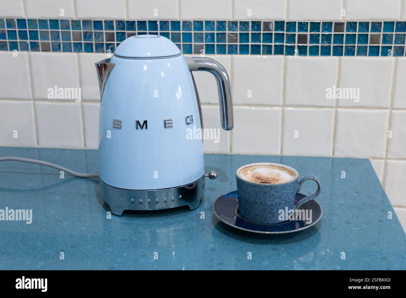 Bollitore blu retrò in stile anni '50 di Smeg con una tazza di caffè - un produttore di elettrodomestici di lusso di marca italiana - in una cucina inglese. REGNO UNITO Foto Stock