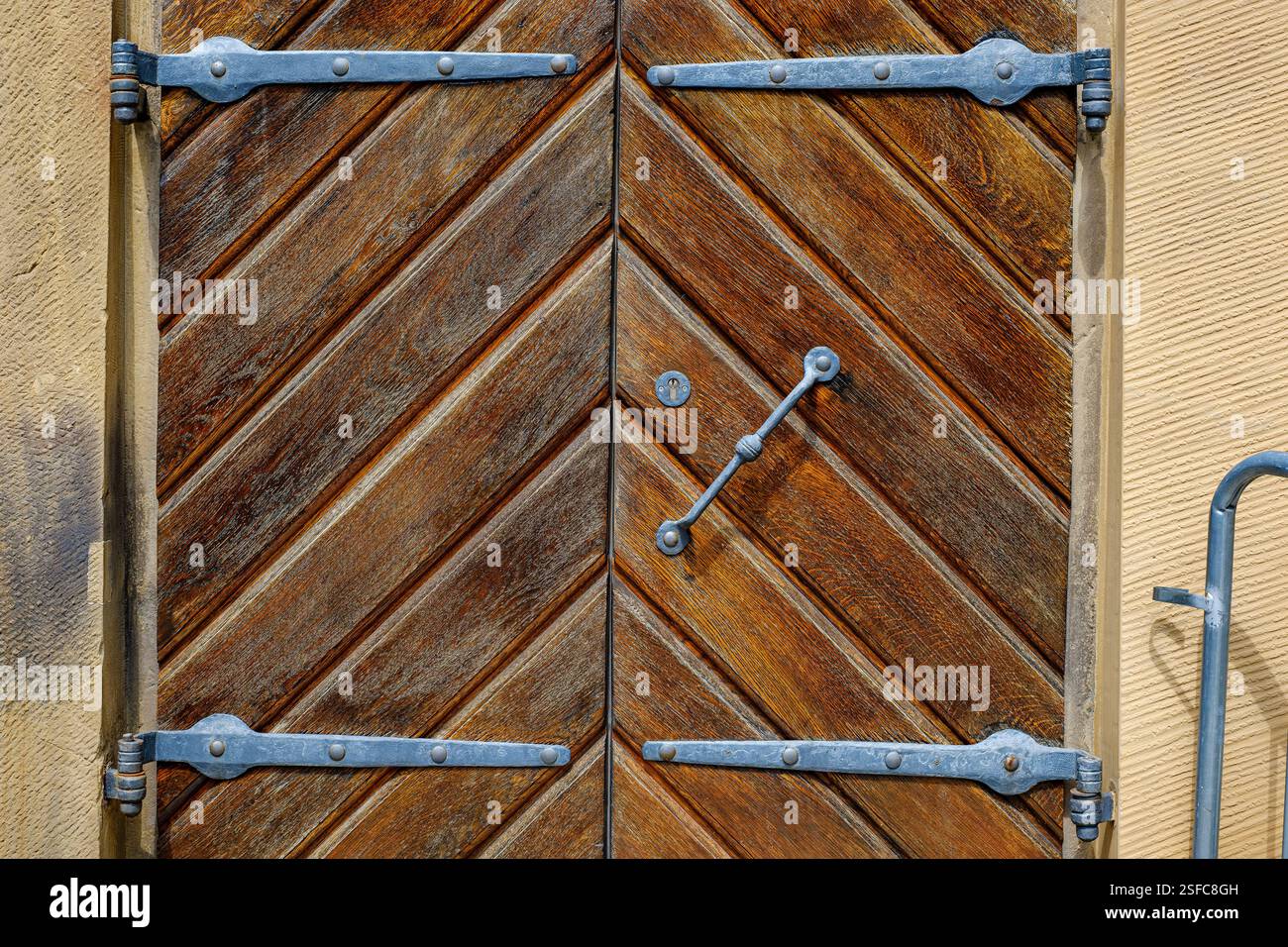 Dettaglio di una storica porta in legno incorniciata in ferro nella parete esterna del Palazzo Vecchio di Stoccarda, Baden-Württemberg, Germania. Foto Stock