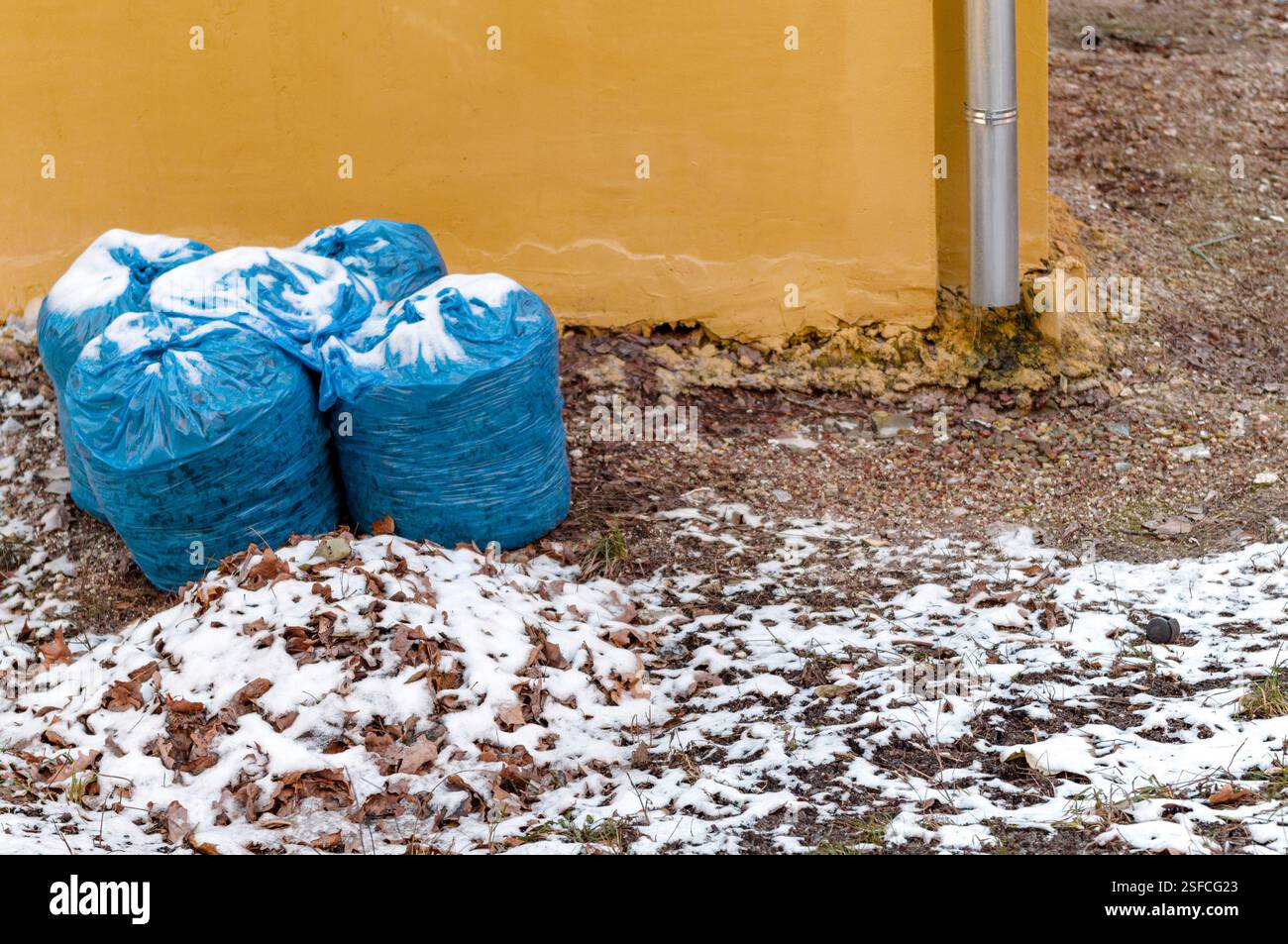 sacchetti di plastica monouso pieni di spazzatura contro il muro, scene invernali Foto Stock