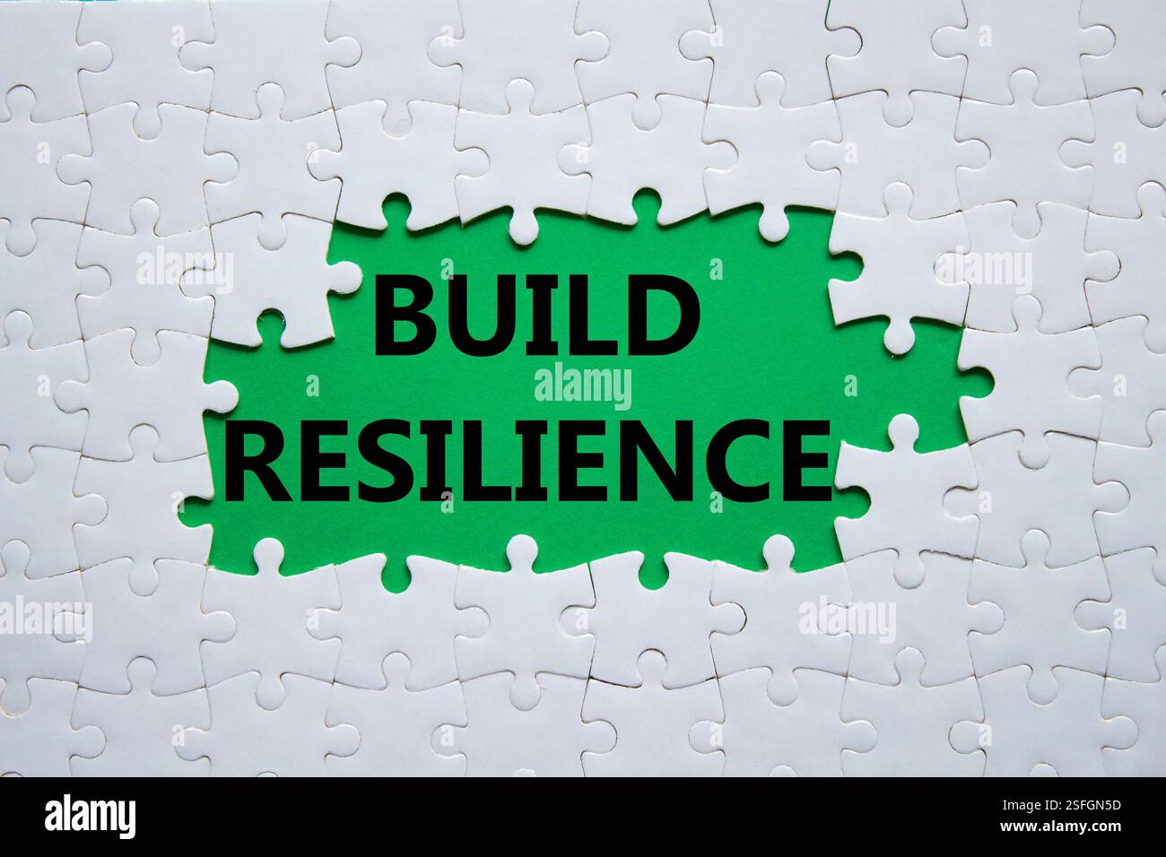 Simbolo di resilienza. Puzzle bianco con parole per una maggiore resilienza. Bellissimo sfondo verde. Business e creazione di un concetto di resilienza. Copia spazio. Foto Stock