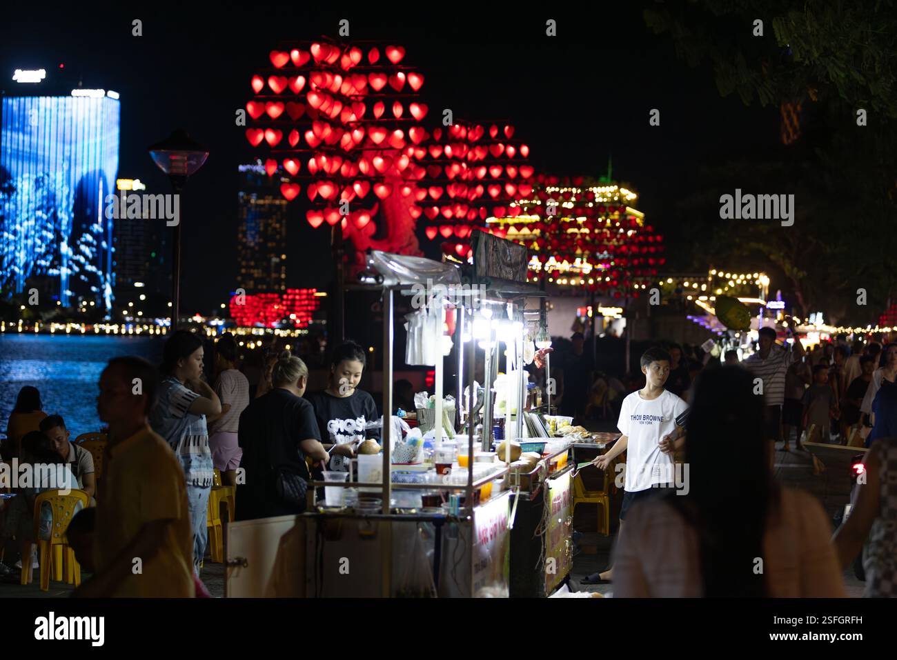 Da Nang, Vietnam - 2 luglio 2024: Il falco vende il cibo vicino al fiume e Son tra Night Martket Foto Stock