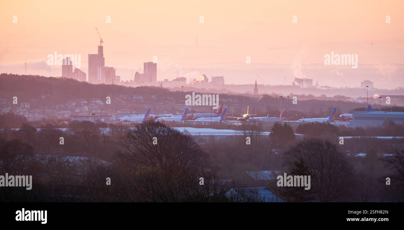 L'aeroporto di Leeds Bradford e lo skyline della città di Leeds sono visibili attraverso la gelida foschia di una fredda alba di febbraio, catturata da Otley Chevin. Foto Stock