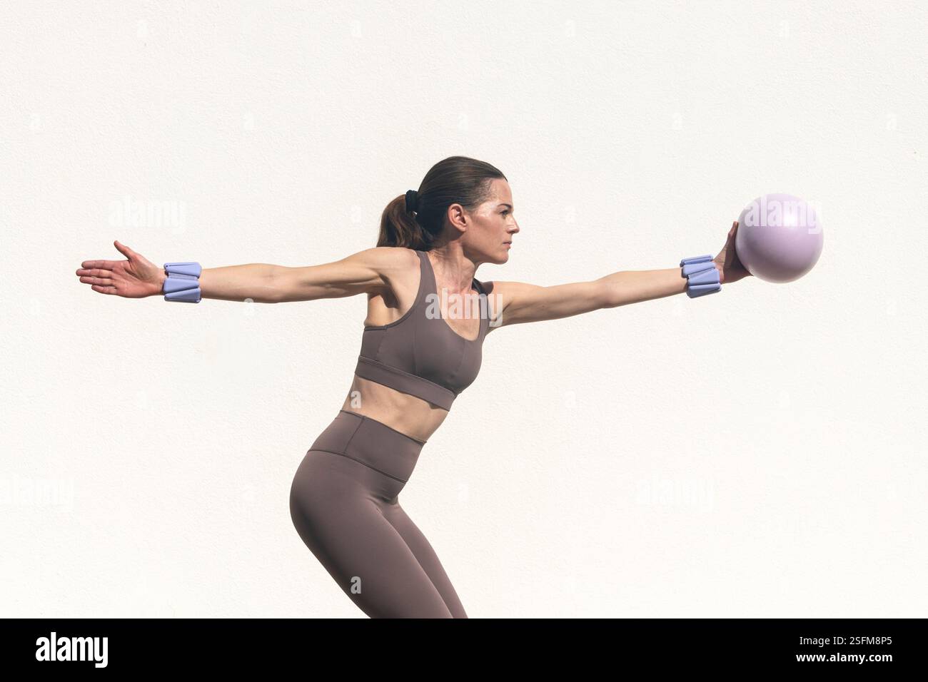 donna sportiva con una palla pilates, esercizi di stretching del braccio. Foto Stock