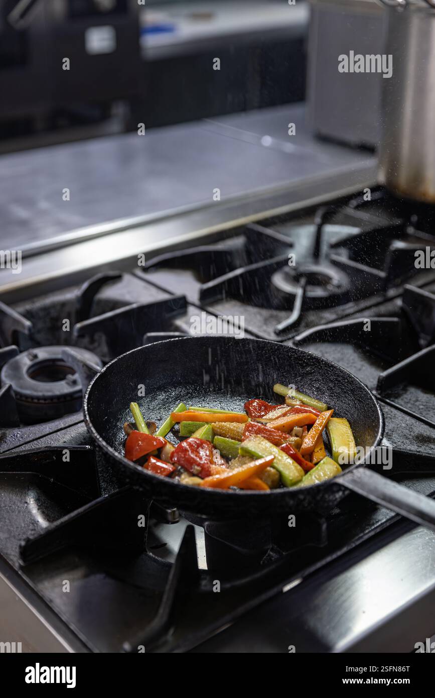 Deliziose verdure grigliate cucinate in una padella nella cucina di un ristorante Foto Stock