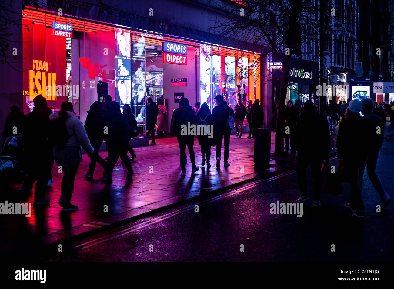 Pedoni che camminano su Oxford Street di notte, Londra, Inghilterra, Regno Unito. Foto Stock
