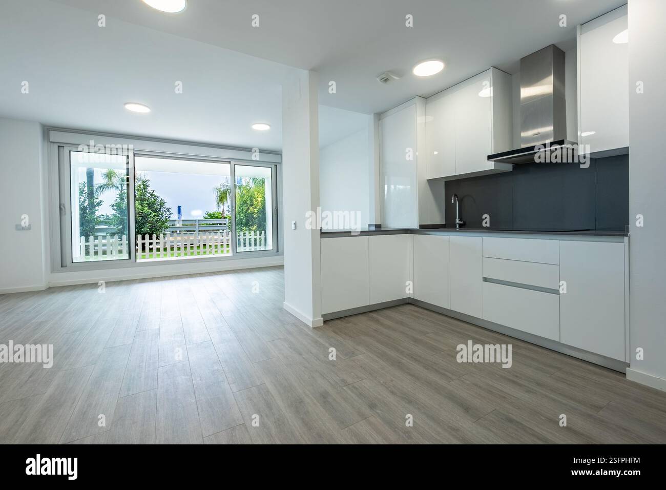 una cucina a vista appena accessoriata che conduce alla terrazza giardino in un lussuoso complesso di appartamenti mediterranei Foto Stock