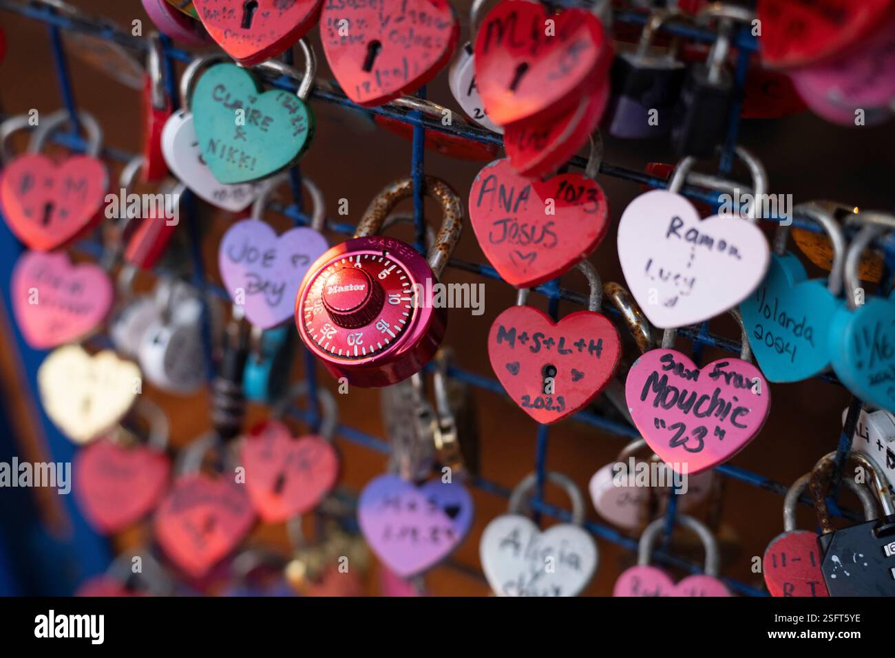 Le serrature d'amore, vari nomi e date, adornano una recinzione metallica Foto Stock