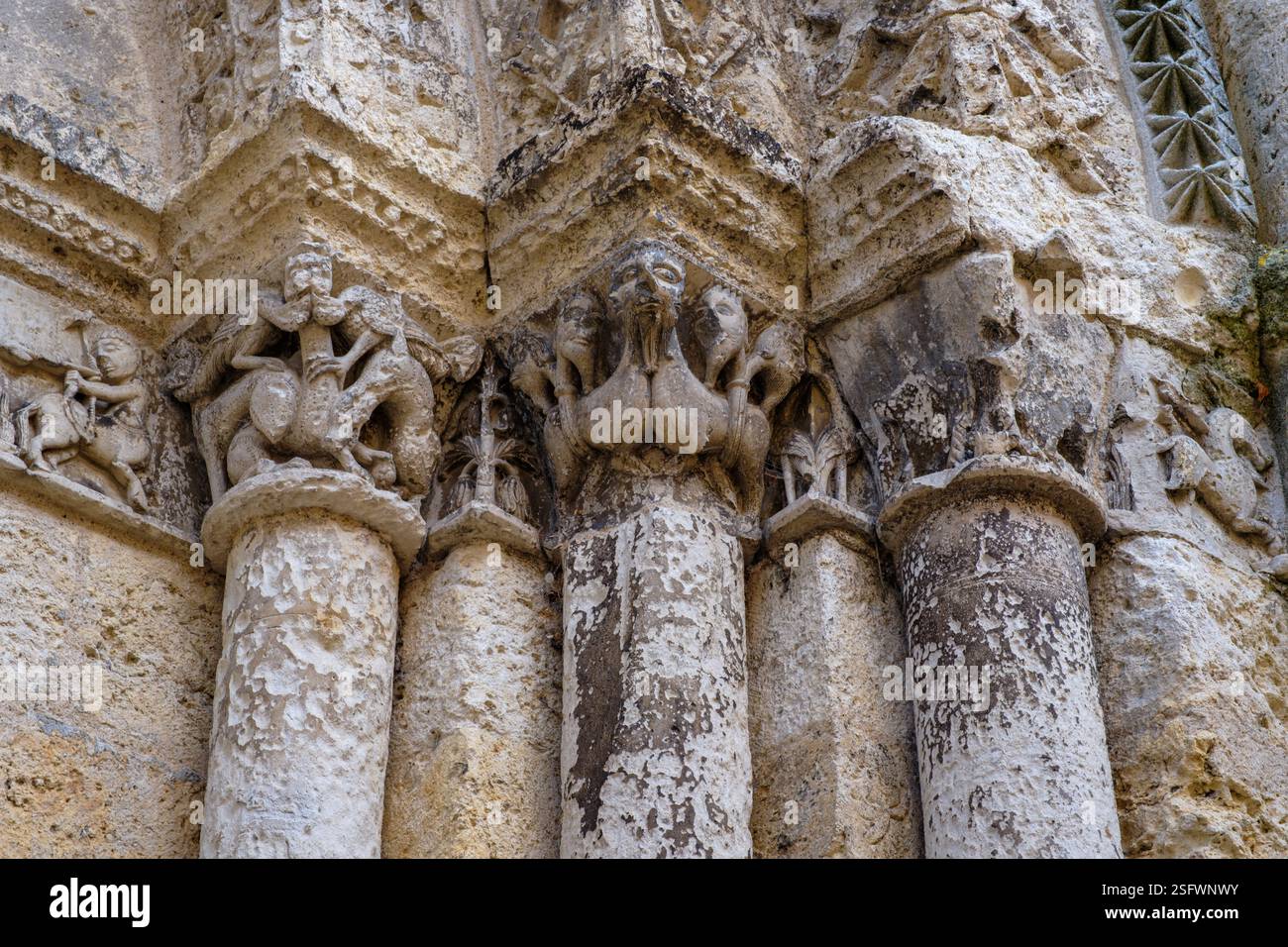 Vista dettagliata su tre incisioni simboliche romaniche su una colonna maiuscola all'esterno della chiesa di Saint-Jacques ad Aubeterre-sur-Dronne Foto Stock