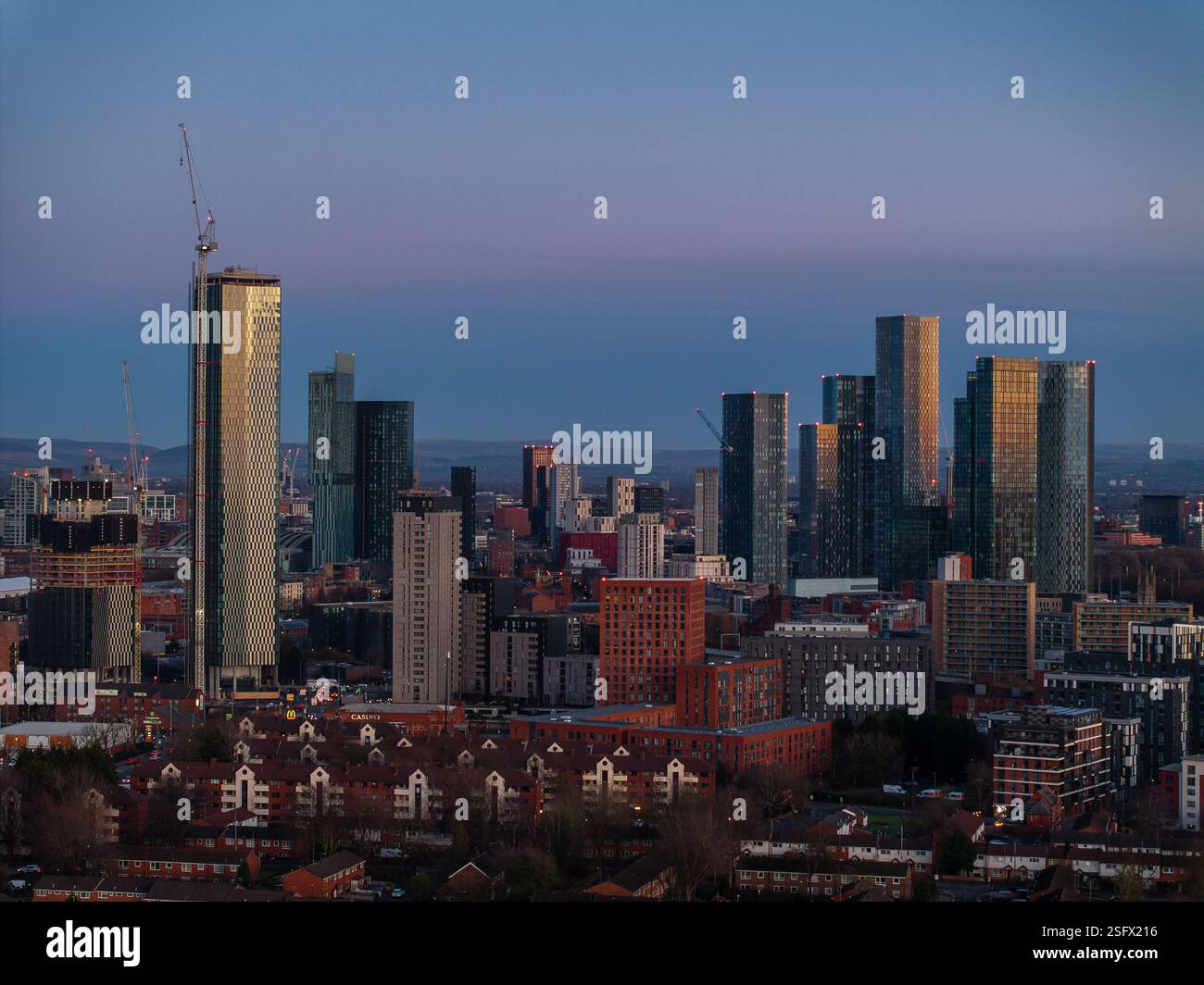 Vivace paesaggio urbano degli edifici moderni di Manchester e dello skyline catturato al tramonto. Grattacieli illuminati e l'architettura urbana rendono la città di gro Foto Stock